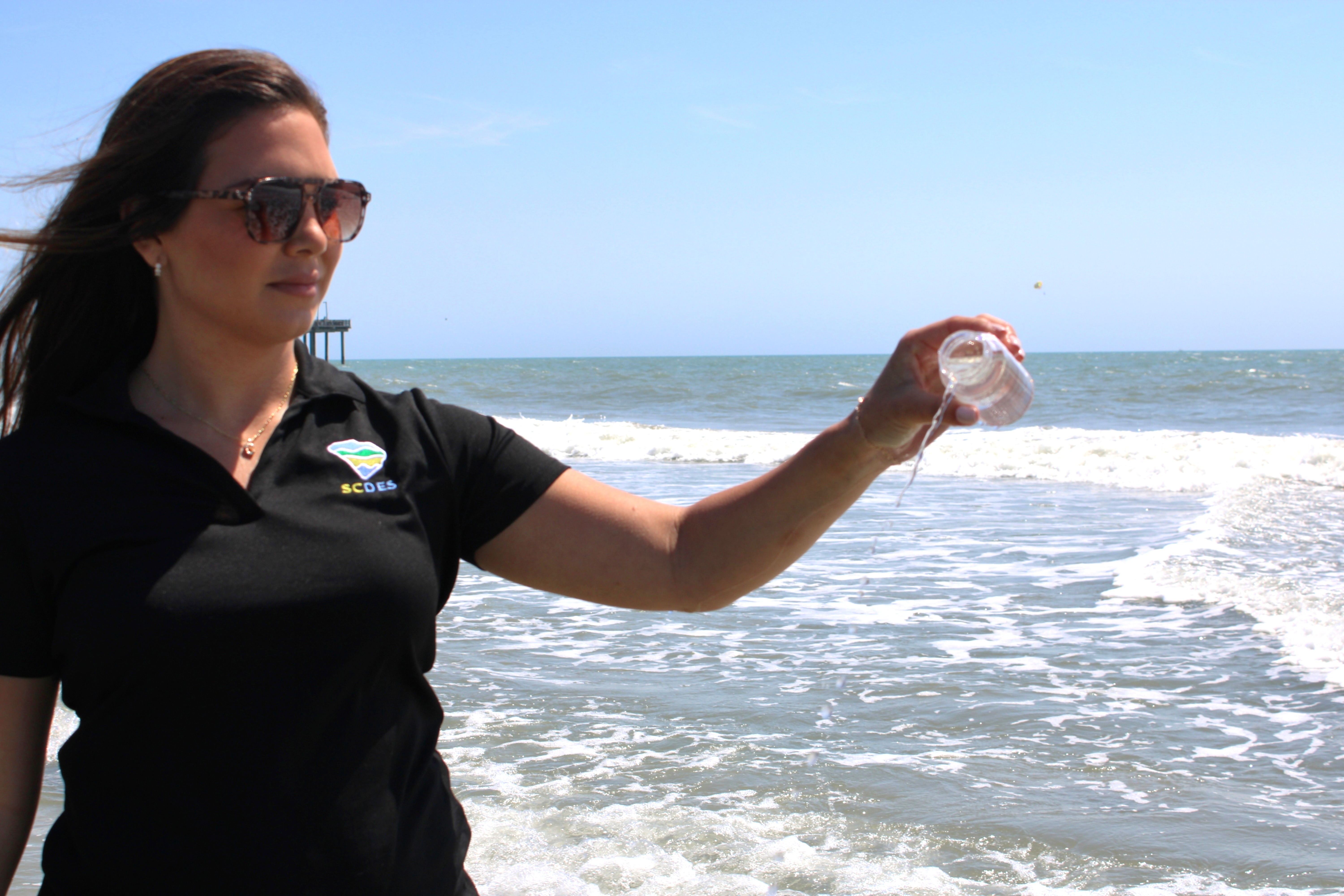 Beach monitor collects a water sample