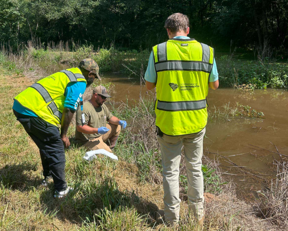 SCDES employees collect water samples.