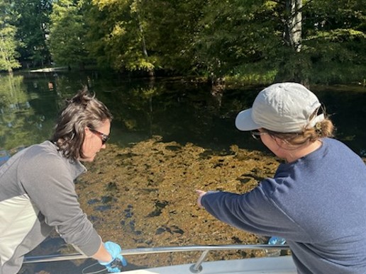 two people in a boat wearing gloves and monitoring samples